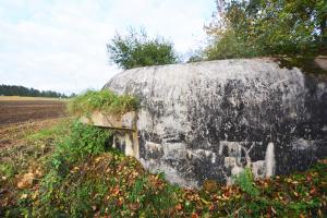 Ligne Maginot - PC de St Walfroy (IV / 155e RIF) - Le coté du bâtiment dégagé de l'empierrement devant le protéger laisse apparait la cunette permettant de recueillir les eaux de pluie tombant sur la dalle.