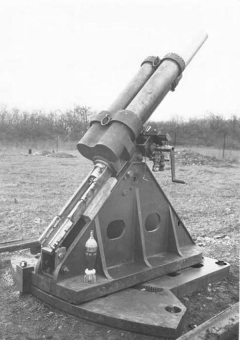 Ligne Maginot - Mortier de 81 mm mle 1932 - Mortier de 81 pour tourelle (commandes de pointage à droite) sur affut de casemate lors des essais du matériel.
Noter la présence d'un obus de 81 mle 32 avec une charge additionnelle posé sur le support.