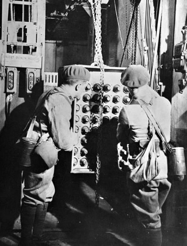 Ligne Maginot - Transport des munitions dans un ouvrage - Un châssis chargé d'obus en cours de transfert en haut d'un bloc. Noter la continuité du monorail entre le bloc et le monte charge.