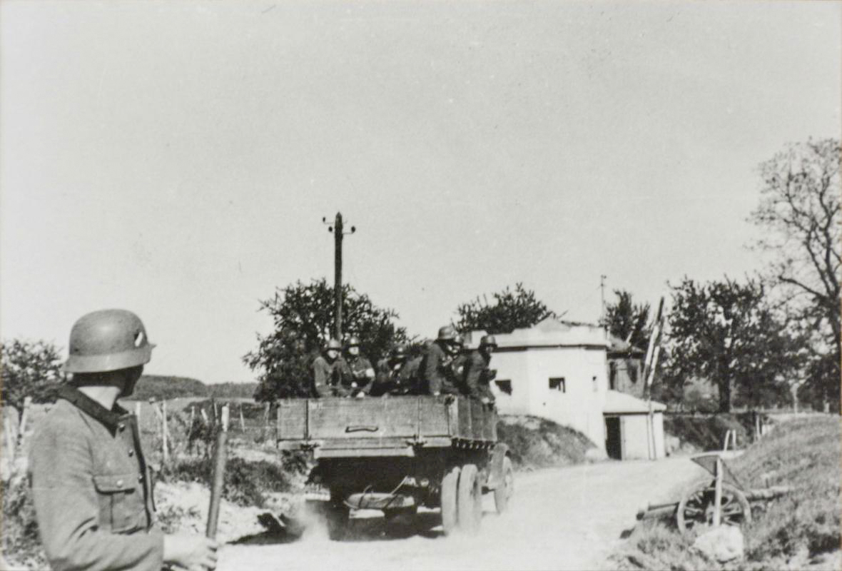 Ligne Maginot - SPICHEREN (MF DE) - (Poste GRM - Maison Forte) - Vue du coté route, les allemands passent devant l'avant poste dont la barrière a été réouverte.
Noter que l'avant poste ne comporte aucune trace de combat et que la partie casernement à l'arrière  est intacte