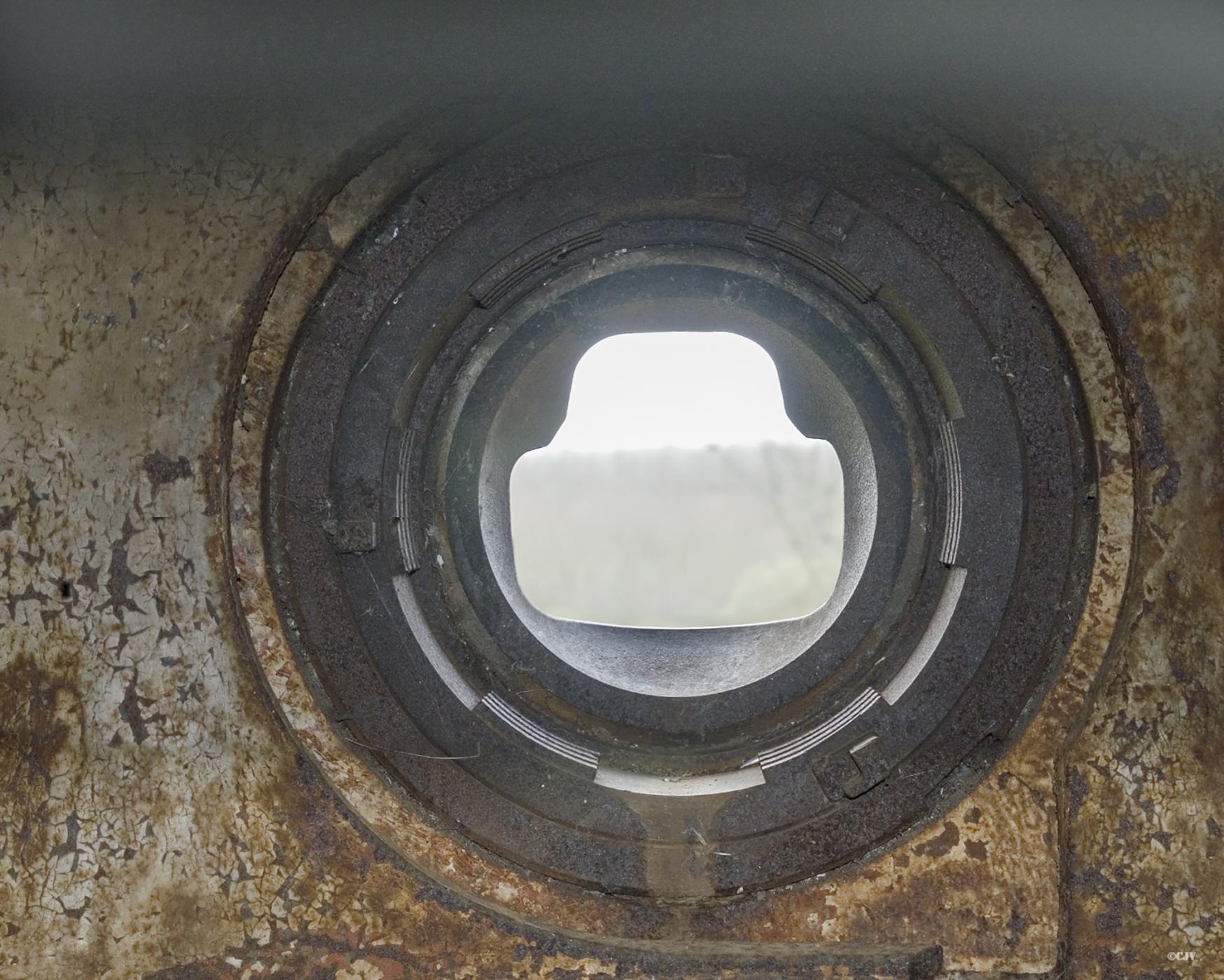 Ligne Maginot - Casemate d'infanterie de JENLAIN - C14 - L'intérieur d'une cloche modéle 1934 type B.
L'un des deux créneaux pour l'arme mixte vu de l'intérieur de la cloche 
Le système de verrouillage de la rotule est bien visible sur cette photo