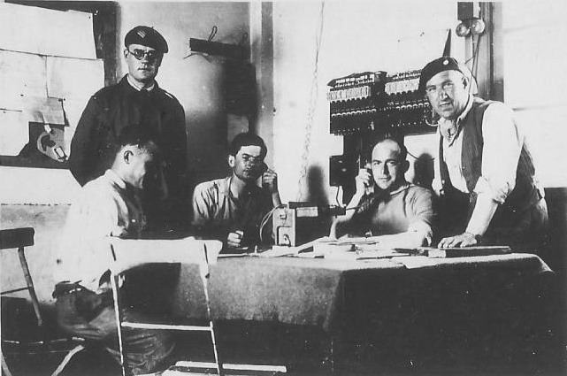 Ligne Maginot - SOULTZ SOUS FORET - (Infrastructure ferroviaire) - Soultz-sous-Forêts, 1939-40. Le poste de régulation du trafic.
Le sous-officier debout à gauche est le chef régulateur, le personnage assis au centre étant le Lt Durupt, responsable du réseau de communications, l’autre homme au téléphone, le Lt Guérin, chef des ateliers de réparations 